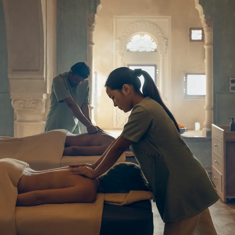 客人可在明亮的水疗室中接受背部按摩治疗,水疗室采用自然光线,拱形窗户的设计灵感来自当地建筑。.