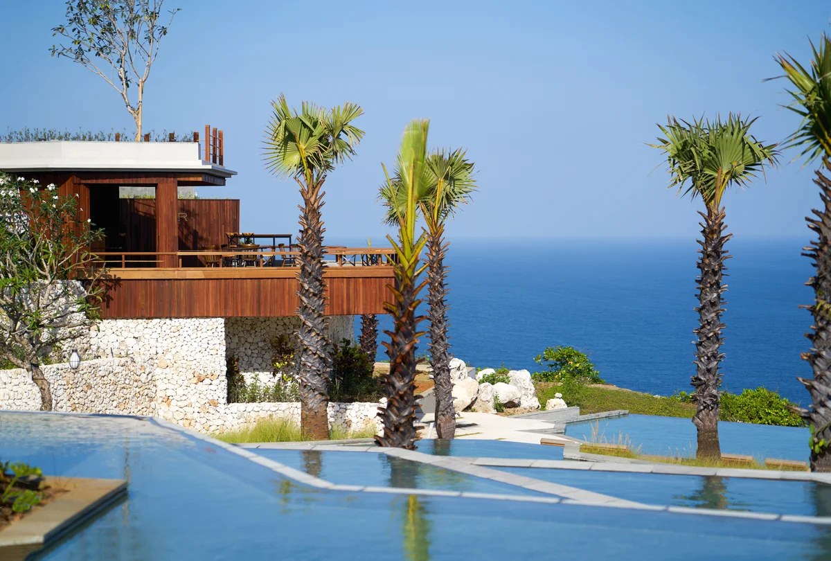 Palms and pools in front of the timber Bar at Rocka, raised on a limestone wall above the ocean