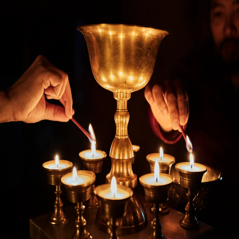 Light a butter lamp during evening prayers at Damchen Lhakhang followed by an intimate Cow Shed dinner cooked over a traditional clay stove by candlelight.