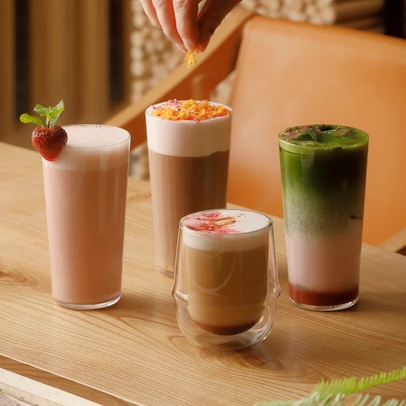 木製のテーブルの上に3種類のドリンクが並べられ、フレッシュなイチゴがアクセントになっている。.