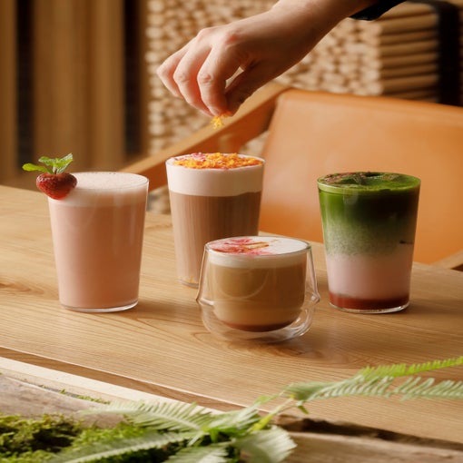 木製のテーブルの上に3種類のドリンクが並べられ、フレッシュなイチゴがアクセントになっている。.