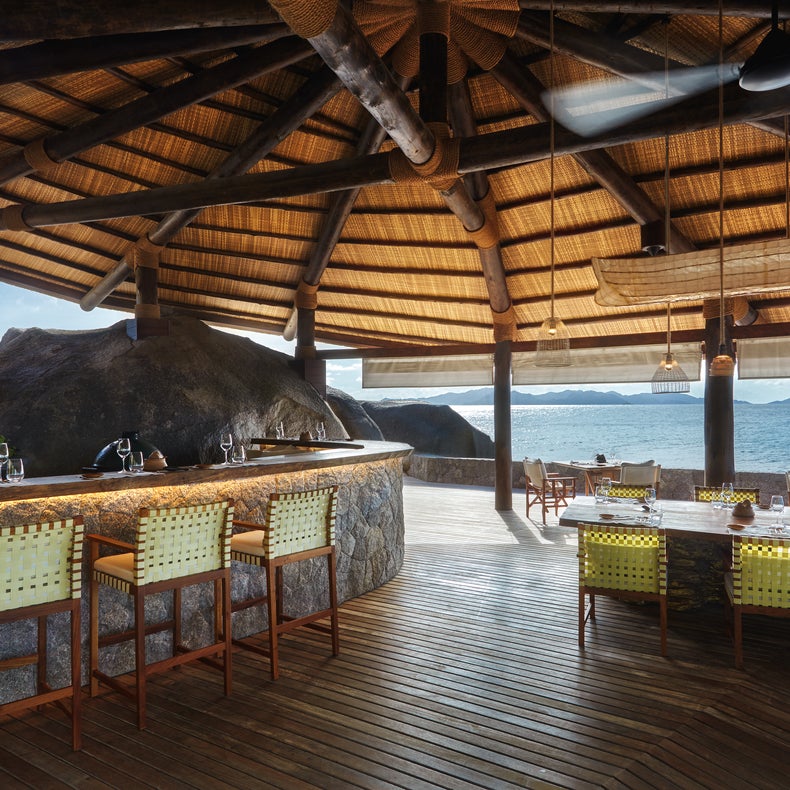 El cuidado diseño de la zona del bar, con sillas de madera natural e iluminación ambiental, crea un ambiente relajado que hace hincapié en la comodidad y la cordialidad.