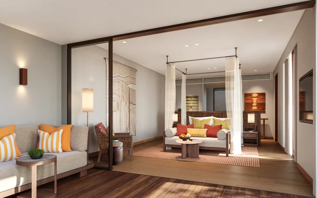 Chambre spacieuse dotée d'un lit à baldaquin, d'un canapé, d'une décoration aux tons terre apaisants rehaussée de touches d'orange, d'un parquet en bois naturel et d'un éclairage d'ambiance tamisé.