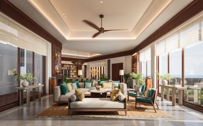 Living area with floor-to-ceiling windows, comfortable seating, greenery, ceiling fan, natural light, and ocean views. Sustainable design elements featured.