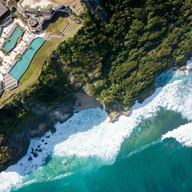 度假村的泳池位于茂密的绿色植物和岩石悬崖旁,毗邻岸边碧绿的海浪。宁静、与自然融为一体的环境体现了健康和可持续发展的价值观。.