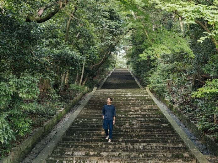 Những bậc thang đá rộng dẫn lối qua những hàng cây xanh mát trong một khu rừng yên bình, mời gọi một hành trình tĩnh lặng trong thiên nhiên, kết nối với sức khỏe và sự hài hòa với môi trường.