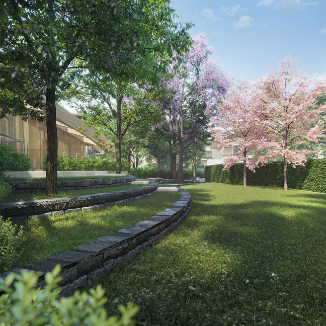 景观区内有弧形石座、开满绿色和粉色花朵的各种树木,以及天空中散布的云朵下的远处建筑。.