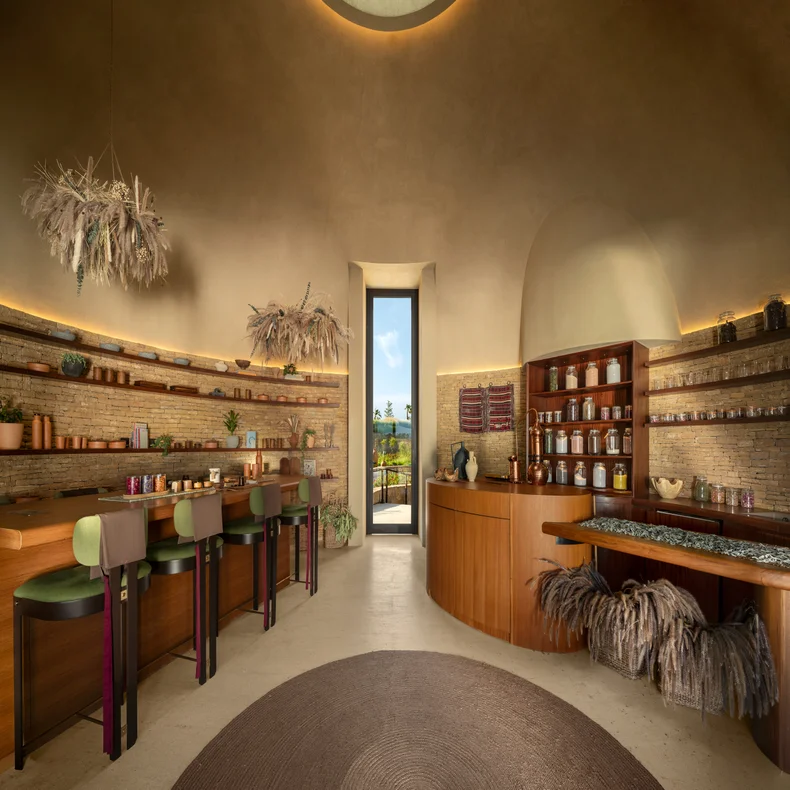Wooden counters and shelves hold glass jars in a calming apothecary. Soft lighting and a doorway frame views of vibrant greenery outside, reflecting wellness and nature.