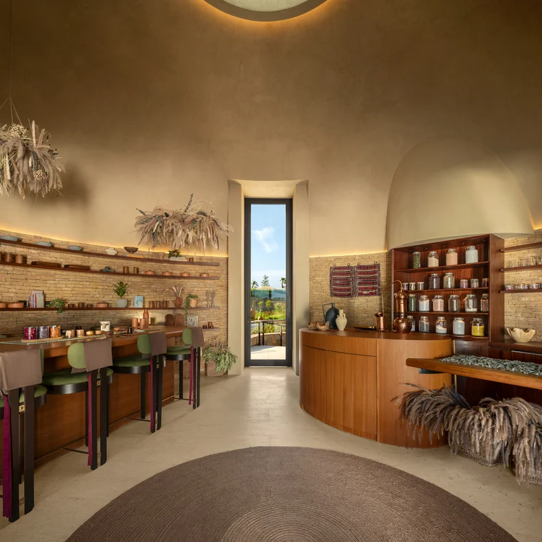 Wooden counters and shelves hold glass jars in a calming apothecary. Soft lighting and a doorway frame views of vibrant greenery outside, reflecting wellness and nature.
