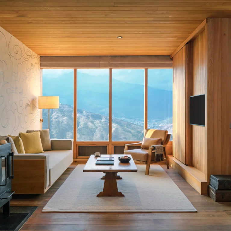 起居室采用可持续木材装饰,透过大窗户可欣赏山景,设有舒适的座椅、燃木炉、茶几和壁挂式电视。柔和的日光提升了舒适度。.