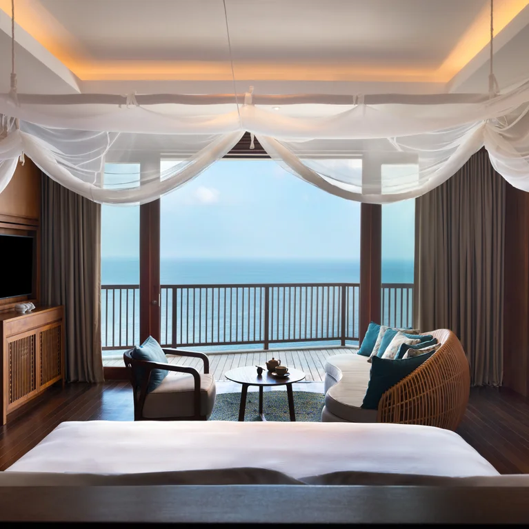 宽敞的酒店客房配有天篷床、休息区、电视和通向阳台的大窗户,可欣赏到海景。.