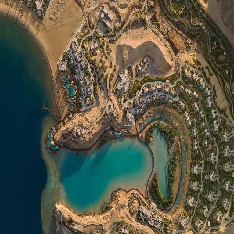 Coastal resort set by blue sea, soft sand beaches, winding paths, private villas and thriving greenery designed with wellbeing and sustainability in mind.