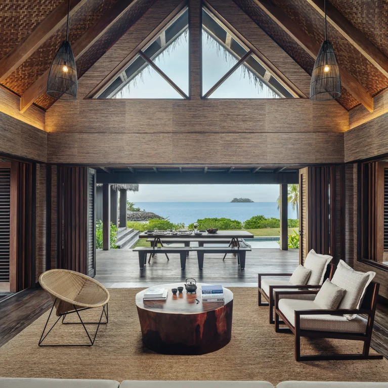 起居区采用天然木质细节,宽大的落地窗将大海尽收眼底;室外露台和丰富的绿色植物加强了室内外的联系。.