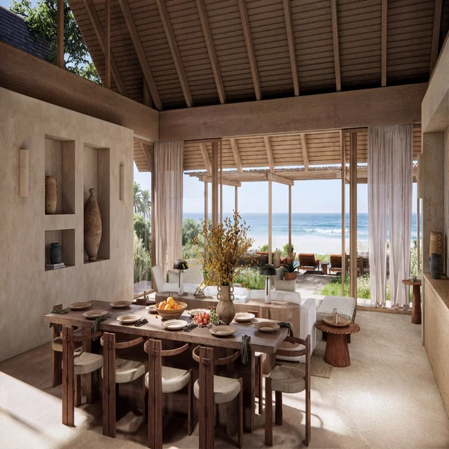 Dining and lounge space featuring natural wood furnishings, expansive windows, and views of the ocean softened by sheer curtains.