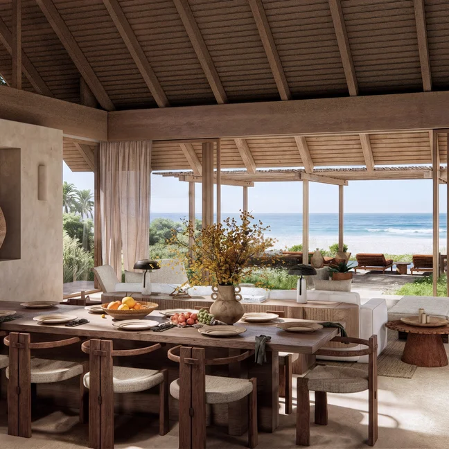 Dining and lounge space featuring natural wood furnishings, expansive windows, and views of the ocean softened by sheer curtains.